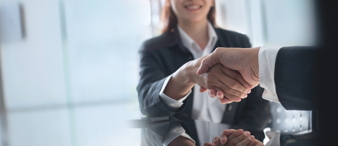  Improving Business Adaptability, A woman in a suit shaking another persons hand