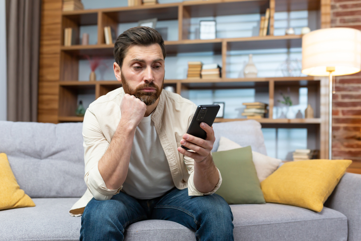Customer checking phone while waiting for a response, illustrating delayed follow-up and missed business opportunities